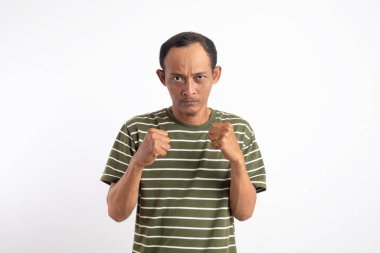 Saldırgan Asyalı adam kameraya karşı dövüşmeye çalışıyor, yumruğunu sallıyor, ifadeyle boks yapıyor, cezalandırıyor, tehdit ediyor, taciz ediyor, öfkeden kuduruyor. Beyaz stüdyo geçmişinde izole edilmiş yakışıklı adam.