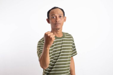 Saldırgan Asyalı adam kameraya karşı dövüşmeye çalışıyor, yumruğunu sallıyor, ifadeyle boks yapıyor, cezalandırıyor, tehdit ediyor, taciz ediyor, öfkeden kuduruyor. Beyaz stüdyo geçmişinde izole edilmiş yakışıklı adam.