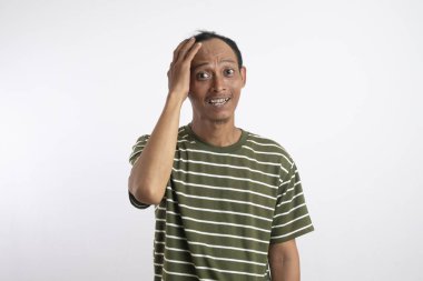 Kafası karışmamış, kafası kazınmamış bir adam, bir şey hakkında derin düşünüyor, kızgın görünüyor, günlük kıyafetler giyiyor, beyaz arka plana karşı duruyor. İnsan yüz ifadeleri, duygu konsepti