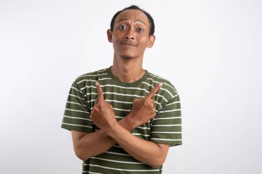 Yeşil tişörtlü Asyalı bir adam, sanki bir reklam aracı için beklenmedik bir şey fark ediyormuş gibi, şaşırmış ve meraklı bir ifadeyle yan tarafı işaret ediyor. Beyaz arka plan onun heyecanlı ifadesini vurguluyor..