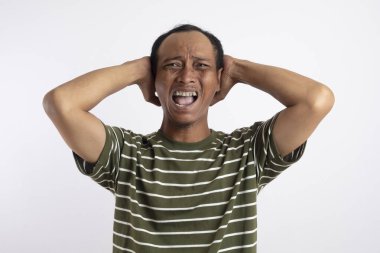 Asyalı bir adam başını baş ağrısı ifadesi olarak tutarak ne kadar acı verici olduğunu gösteren çığlıklar attı..