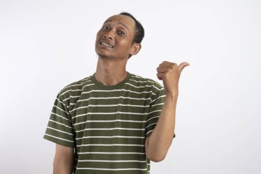 Beyaz çizgili yeşil gömlekli bir adam sıcak bir şekilde gülümser ve olumlu ve onaylı bir jest yapar. Açık mavi arka plan, onun neşeli ve kendinden emin tavırlarını vurguluyor..