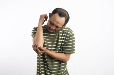 Yoksul genç Avrupalı yakışıklı adam elini hassas noktaya bastırıyor ve dirsek ağrısı çekiyor. Dirsek ağrısı çeken genç bir adam. İnsanlar, sağlık ve sorun konsepti - elinde acı çeken mutsuz bir adam.