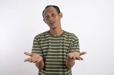 Şok olmuş Asyalı bir adamın portresi, yeşil tişört giymiş, beyaz bir arka planla izole edilmiş.