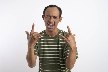 Süper havalı bir adam, rock metal işareti yapıyor, elleri kameranın önünde, eğlenceli punk müziğini pozitif enerjiyle ifade ediyor. Erkek hippi rockçı eğlence için şeytan boynuzu işareti yapıyor..