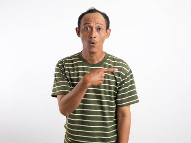 Şok olmuş Asyalı yeşil gömlekli adam yanındaki fotokopi alanını işaret ediyor, beyaz arka planla izole edilmiş.