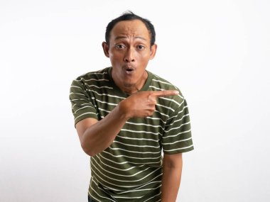 Şok olmuş Asyalı yeşil gömlekli adam yanındaki fotokopi alanını işaret ediyor, beyaz arka planla izole edilmiş.