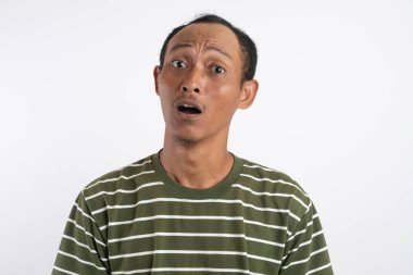 Ciddi ve tarafsız bir ifadeyle ya da boş bir suratla kameraya bakan genç bir adam..