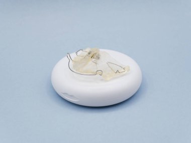 Ortodontik diş teli, diş hizasını korumak için bir diş aygıtı, koruyucu depolama çantasının üzerinde dinleniyor.