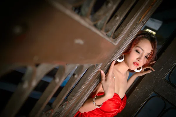 Mode-Foto von jungen asiatischen Frau in rotem Kleid Stockbild