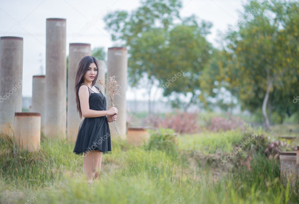 Asian girl in a meadow , light evenings