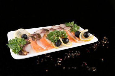 Dilim balık, limon ve zeytin tarafından dekore edilmiş