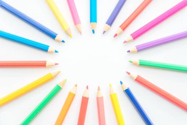 Renkli kalemler, temiz beyaz arkaplanda fotokopi alanı ile parlak dairesel bir çerçeve oluşturuyorlar. Başlıklar, öğrenme, çocuk sınıfları ve oyuncu tasarım kavramları için yaratıcı, eğitici, sanatsal bir düzen.