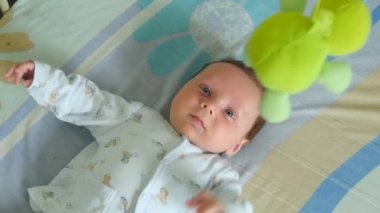 Oyuncak ile beşik içinde yatan küçük şirin oğlu