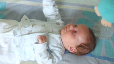Oyuncak ile beşik içinde yatan küçük şirin oğlu