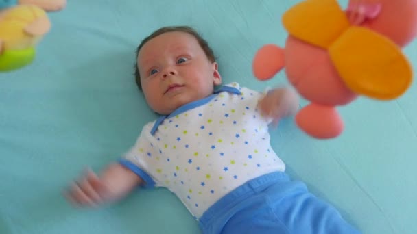 Baby blickt zu einem mobilen Spielzeug auf — Stockvideo