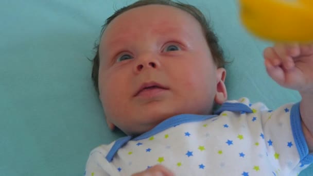 Baby blickt zu einem mobilen Spielzeug auf — Stockvideo