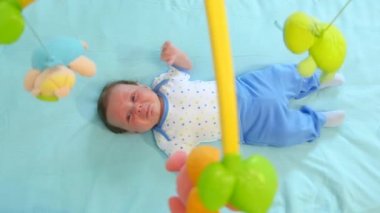 Oyuncak ile beşik içinde yatan küçük şirin oğlu