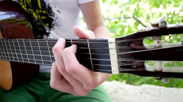 Młody człowiek gra gitara samotnie zwolnionym tempie — Wideo stockowe