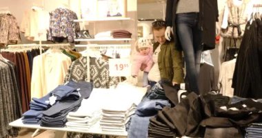 Alışveriş sırasında bebek giysileri seçerek kadınla