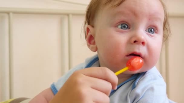 Babyjongen eten een lolly — Stockvideo