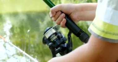 nehir üzerinde iplik ile balık tutan çocuk