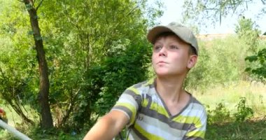 nehir üzerinde iplik ile balık tutan çocuk