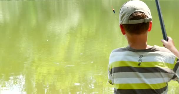 附近的河里钓鱼的男孩 — 图库视频影像