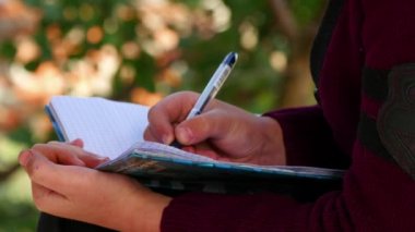 Ağaçlar ve yazma bankta oturmuş çocuk