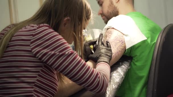 Молода приваблива дівчина б'є татуювання в салон — стокове відео