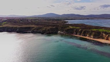 Bu nefes kesici hava çekimi, temiz bir gökyüzü altında kayalık kayalıklar ve canlı suların yer aldığı Bulgaristan 'ın kıyı şeridini gösteriyor. Bereketli arazi uzak tepelere doğru uzanıyor..