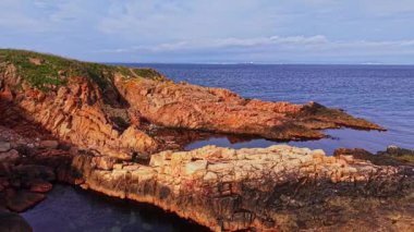 Bu hava manzarası Bulgaristan 'ın engebeli kıyı şeridini gösteriyor. İnsansız hava aracı kayalık oluşumları ve sakin suları yakalar, güneşin batışında doğanın güzelliğini gösterir..