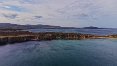 Bu çarpıcı hava manzarası, Bulgaristan 'ın çeşitli kıyı şeridini, bulutlu bir gökyüzünün altında sakin bir deniz boyunca kayalıklar ve kumlu kıyıları gösteriyor..