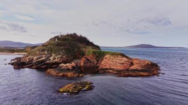 İnsansız hava aracı Bulgaristan 'daki tenha bir adanın çarpıcı bir görüntüsünü yakalıyor, kayalık kayalıklar, berrak sular ve bulutlu bir gökyüzünün altında uzak bir kıyı şeridi sergiliyor..