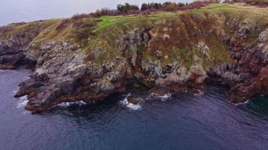 Sersemletici hava perspektifi Bulgaristan 'daki engebeli kıyı uçurumlarını yakalayarak karmaşık kaya oluşumlarını ve aşağıdaki sakin denizi ortaya çıkarıyor. Doğa meraklıları için mükemmel..