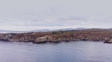 Bu hava görüntüsü, Bulgaristan 'ın engebeli uçurumları, sakin suları ve sonbaharda bulutlu bir gökyüzünün altındaki uzak dağları gösteren güzel kıyı şeridini yakalıyor..