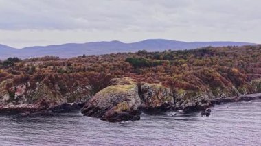 Bu hava çekimi, Bulgaristan 'ın kıyı şeridinin engebeli güzelliğini, kayalık oluşumları ve su kenarında canlı yeşillikleri yansıtıyor. Sahne huzur dolu..