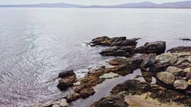 Sersemletici insansız hava aracı atışı Bulgaristan 'ın engebeli kıyı şeridini yakalıyor, yumuşak bulutlu gökyüzü altında kayalık oluşumlar ve sakin sular sergiliyor. Doğanın güzelliği açılır.