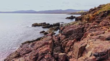 Bu hava görüntüsü Bulgaristan 'ın engebeli kayalık kıyı şeridini sakin suları ve bulutlu gökyüzünün altındaki uzak dağlarla yakalıyor ve bölgenin doğal güzelliğini vurguluyor..