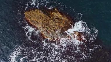 Drone, Bulgaristan 'ın güzel kıyı şeridi boyunca dönen dalgalarla çevrili kayalık bir çıkıntının çarpıcı hava görüntüsünü yakalıyor. Sahne doğal güzelliği vurgular.