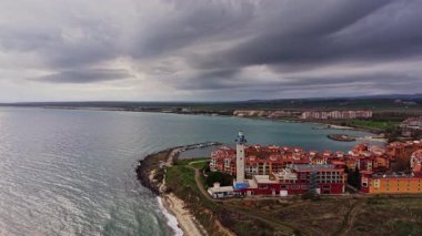 Bu İHA görüntüsü, Bulgaristan 'ın önde gelen deniz feneri, kayalık kıyıları ve dramatik bulutların yer aldığı manzaralı bir kıyı kasabasını gösteriyor..