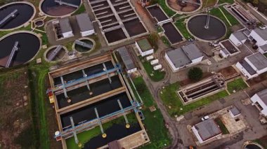 Su arıtma tesisinin havadan görüntüsü çeşitli tankları, filtreleme sistemlerini ve işleme birimlerini gösteriyor. Suyu verimli bir şekilde arıtmak için birlikte çalışıyorlar..