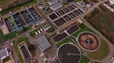 Su arıtma tesisinin çeşitli tankları ve işleme alanlarını gösteren hava görüntüsü. Tesis, gelişmiş tedavi yöntemlerinin sergilendiği kentsel bir bölgede yer alıyor..