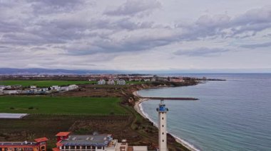 İnsansız hava aracı Bulgaristan 'ın güzel kıyı şeridini yakalıyor, yeşil alanlar, dalgalar ve bulutlu bir gökyüzünün altında bir deniz feneri sergiliyor. Doğa ve mimariye huzurlu bir bakış açısı.