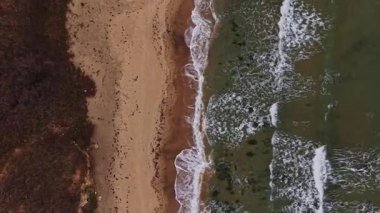 Bu hava sahnesi, kıyıya vuran yumuşak dalgalarla güzel bir Bulgar sahil şeridini yakalıyor. Kumsal yemyeşil bitki örtüsüyle çevrili..