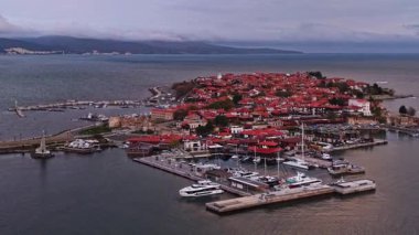 Bulgaristan 'ın tarihi kıyı kasabası Nesebar' ın nefes kesici güzelliğini tecrübe edin. Bu hava manzarası kırmızı çatılı binaları ve marinayı gösteriyor..