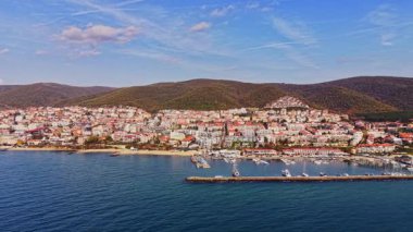 Bulgaristan 'ın canlı kıyı kasabası kıyı boyunca renkli binalar sergiliyor. Huzurlu deniz ve kayıklar açık bir gökyüzünün altındaki manzaraya eklenir..