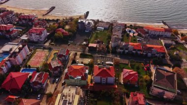 Hava manzarası, Bulgaristan 'da kırmızı çatılı evleri, yeşil çimenleri ve yakınlarındaki bir plajı olan ve huzurlu bir sahil yaşam tarzını yansıtan bir sahil mahallesi gösteriyor..