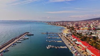 Çarpıcı kıyı şeridine bakan bu manzara, Bulgaristan 'da açık bir gökyüzü altında tekne, kumlu plajlar ve büyüleyici sahil binalarıyla dolu marinayı çekiyor..