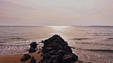 Güzel kayalık kıyı şeridi, Bulgaristan 'ın sakin sularında güneş batarken kayalara çarpan yumuşak dalgaları gözler önüne seriyor..